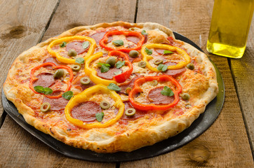 Italian pizza with paprika, salami and olives