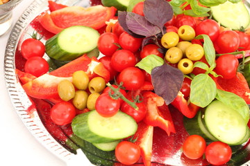plate with vegetables, herbs and olives on the buffet