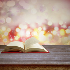 Open book on table in front of abstract background