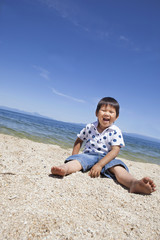 Fototapeta na wymiar 海で笑顔で遊ぶ子供