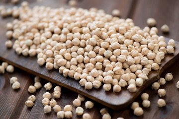 Raw chickpeas on a wooden rustic chopping board, studio shot