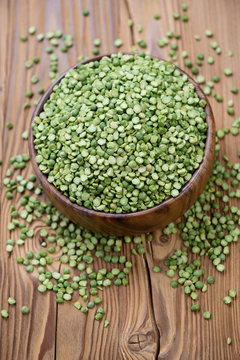 Dried green peas over wooden background, high angle view
