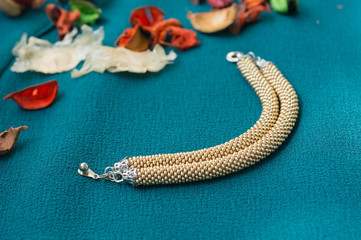 Knitted bracelet from beads of gold color