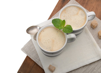 2 cups of coffee with mint on a napkin