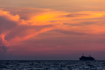 Naklejka na ściany i meble Container cargo ship at sunset, silhouette photo