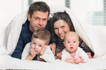 Happy family with children in bed