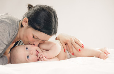 Fototapeta na wymiar Mother kissing happy baby on cheek