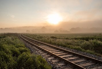 Fototapeta na wymiar Track in misty landscape at sunrise