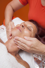 Obraz na płótnie Canvas Cute woman gets professional facial massage, lymphatic drainage