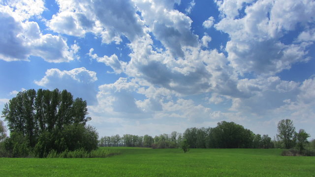timelapse with clouds moving over green meadow