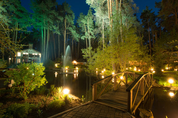 Fototapeta na wymiar Cozy resort by the lake in the conifer forest at night