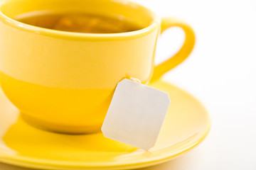 Cup of tea with tea bag (blank label) on white background