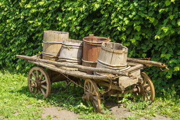 Fototapeta na wymiar Vintage, wooden cart with wooden barrels and buckets