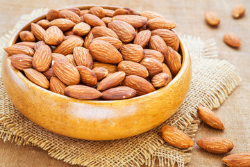 Almonds in wooden bowl on hessian mats