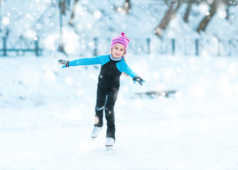 cute little girl  skating in winter outdoors