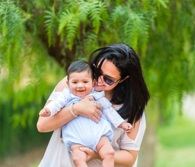 young mother playing with her baby  in the garden