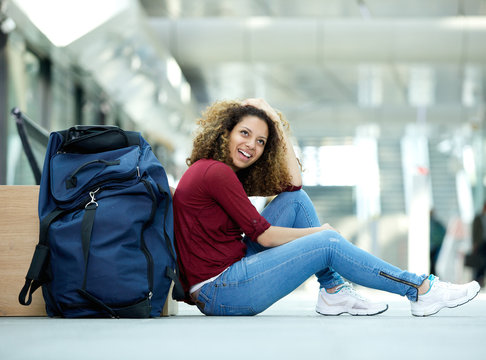Woman smiling with bag at station