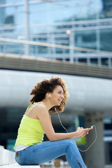 Woman smiling with earphones outside