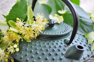 Obraz na płótnie Canvas Teapot with linden tea and flowers, close-up