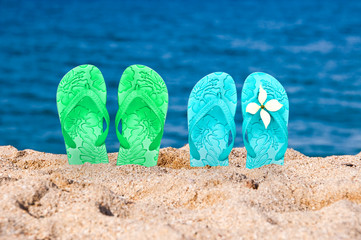 Flip flops of a couple in the sand of a beach