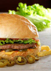 Big juicy Mexican burger with spicy jalapenos, nacho cheese