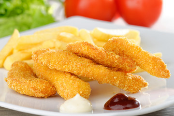 chicken nuggets/sticky fingers and french fries on a white plate