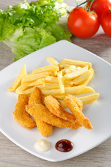 chicken nuggets/sticky fingers and french fries on a white plate
