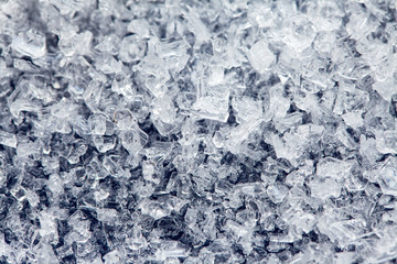 Ice crystals of frozen water on a dark surface