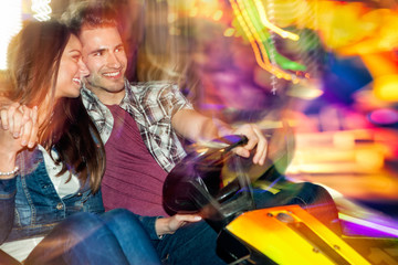 Young couple in love in a bumper car / dodgem ride