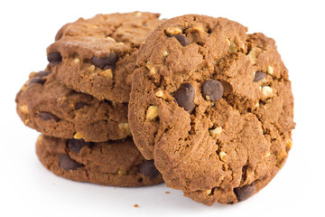 Stack of chocolate chip and nut biscuits with crumbs on white