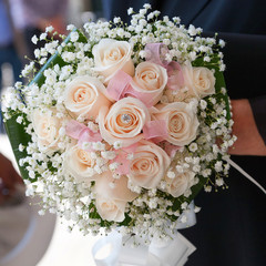 closeup bride holding bouquet of pink roses