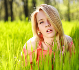 Sensual girl in green grass on a background of nature