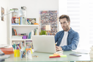 Obraz na płótnie Canvas young man working on a laptop indoors