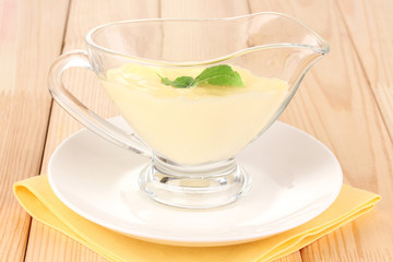Mayonnaise in bowl on wooden table