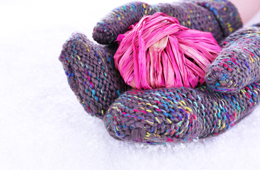 Female hands in mittens with heart on snow background