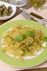 Delicious pasta with pesto on plate on table close-up