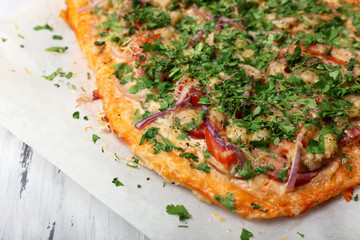 Homemade pizza on baking paper close up