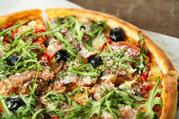 Pizza with arugula on color wooden background