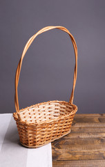 Fototapeta na wymiar Empty wicker basket on wooden table, on dark background