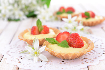 Tasty tartlets with strawberries on table close-up