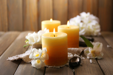 Naklejka na ściany i meble Beautiful candles with flowers on wooden background