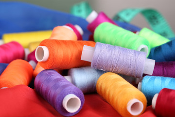 Multicolor sewing threads on color fabric background