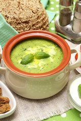 Tasty soup in saucepan on tablecloth, close up