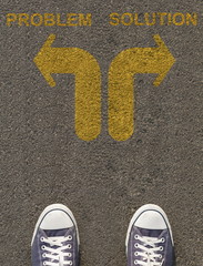 Obraz premium Pair of shoes standing on a road with arrow