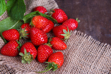 Ripe sweet strawberries in wicker basket and mint leaves