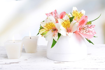 Alstroemeria flowers in vase on table on light background