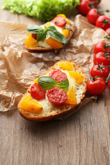 Tasty bruschetta with tomatoes, on old wooden table