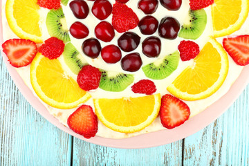 Homemade sweet pizza with fruits on wooden table, close up