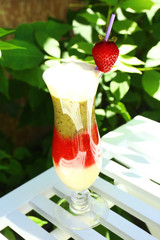 Delicious fruit smoothie on white table, outdoors