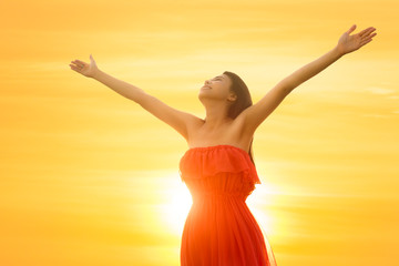 Young asian woman standing open her arms under the sunrise